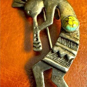 KOKEPELLI brooch. Silver color (not sure of metal). Green in-set stone.